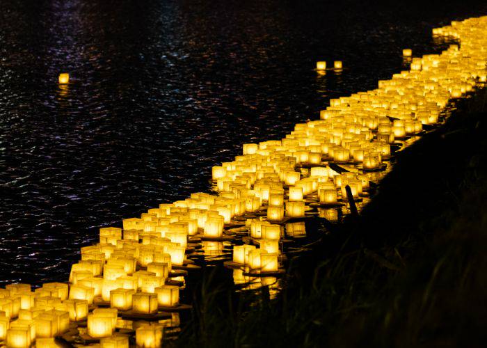 Floating lanterns are a common sight at Obon festivities, floating paper lanterns down local rivers.